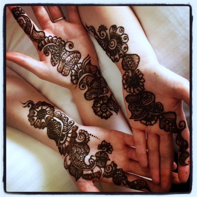 Three hands with henna