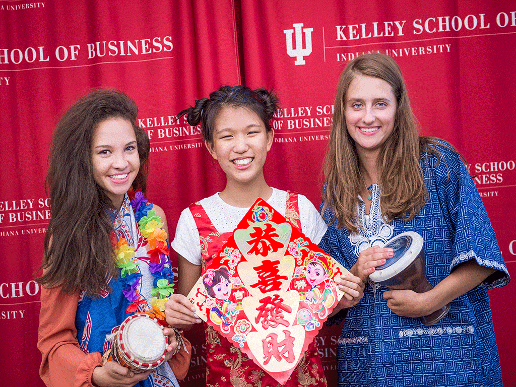 3 high school students standing with cultural items